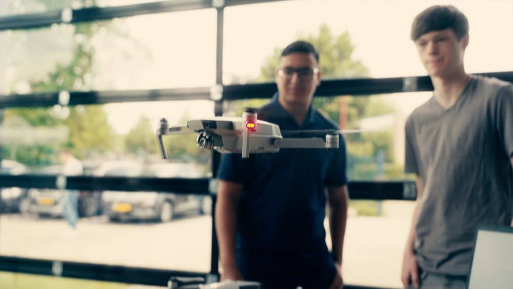 Vliegende drone met 2 jongens op de achtergrond